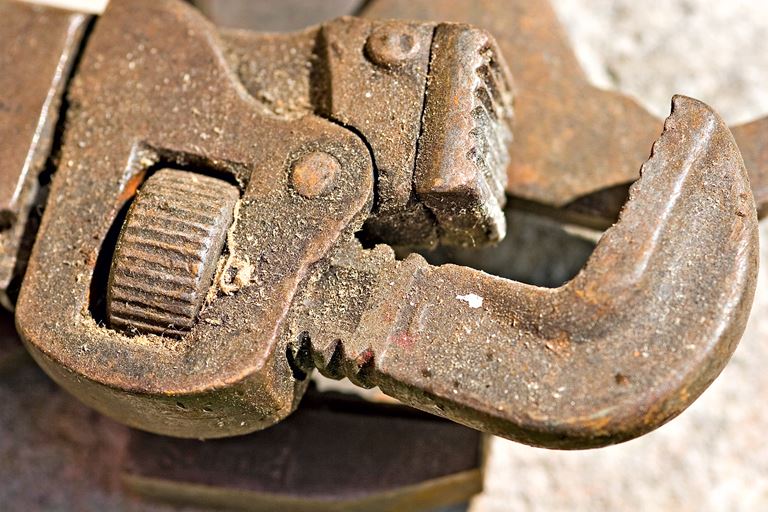 Close-up of slightly rusted, dirty pipe wrench